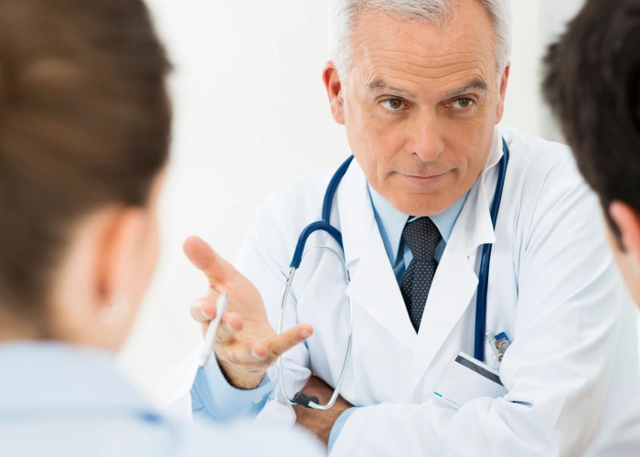 A doctor is talking to another person in front of him.